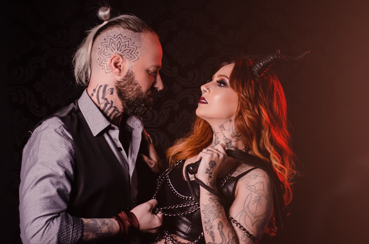services-03 A striking portrait of a tattooed couple in edgy costumes with dramatic lighting.